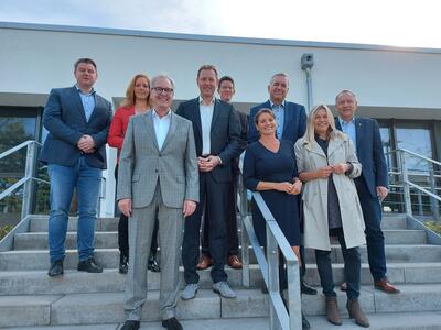 Bild vergrößern: Sechs Mnner und drei Frauen stehen auf einer Treppe. Im Hintergrund ist ein Gebude zu sehen.