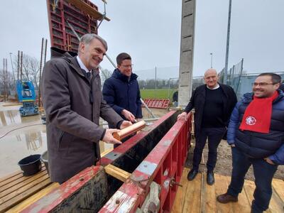 Bild vergr&ouml;&szlig;ern: Eine Gruppe von vier M�nnern steht auf einer Baustelle im Kreis beieinander.
