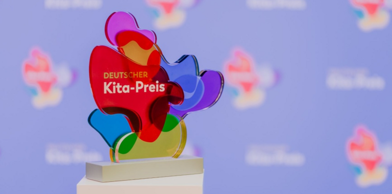 Auf einem Podest ist ein Preis zu sehen. Dieser besteht aus vielen bunten Puzzleteilen.