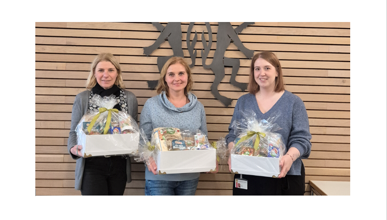 Bild vergr&ouml;&szlig;ern: Drei Frauen stehen vor einer vert�felten Wand mit Kreiswappen und halten je einen Pr�sentkorb in den H�nden.