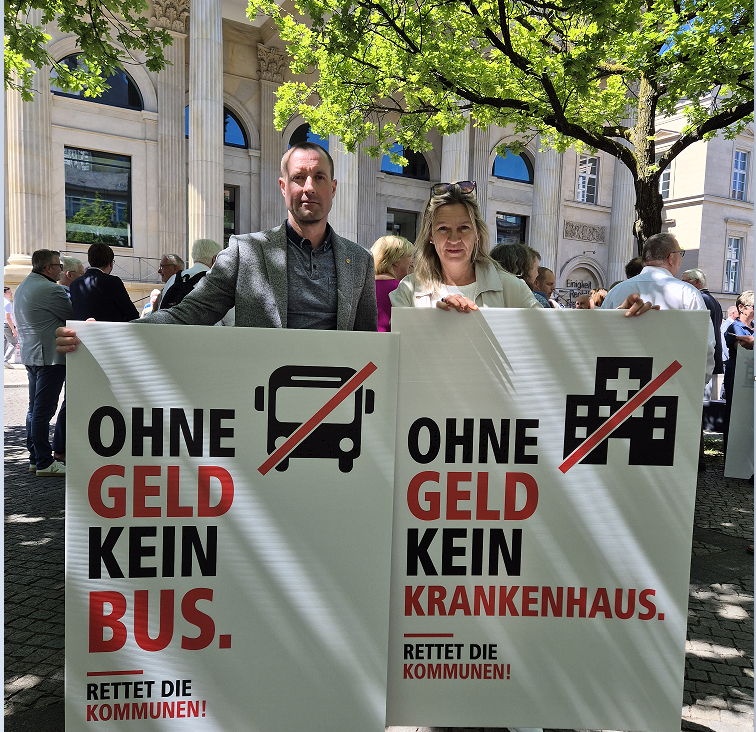 Bild vergr&ouml;&szlig;ern: Eine FRau und ein Mann halten Plakate in den H�nden und blicken ernst in die Kamera.